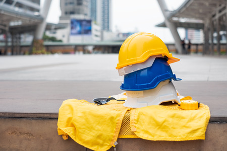 White, blue and yellow safety hard helmet with formal waistcoat for industrial safety workman in the cityの写真素材