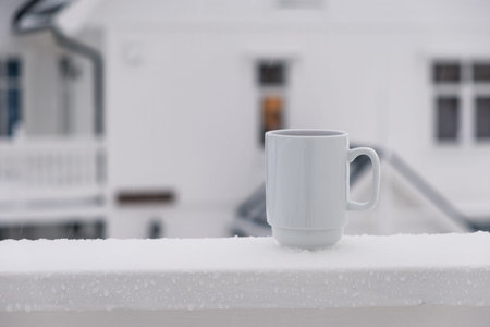 Cranberry juice in white ceramic glass on terrace in winter season
