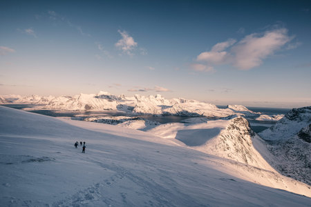 Journey of group traveler on snowy hill at the sunset. Ryten mount, Norway