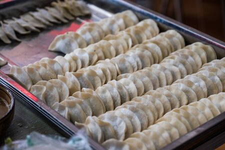 Yellow rows dumplings filling vegetable on trayの写真素材