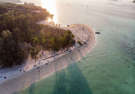 Sunset shining on white sand beach with tropical forest at Lipe islandの写真素材
