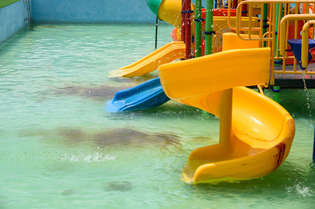 Yellow slider childhood of amusement waterpark with pool