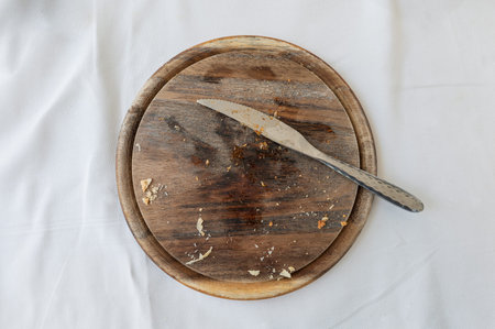 Empty wooden tray with cutlery and bread crumb on table