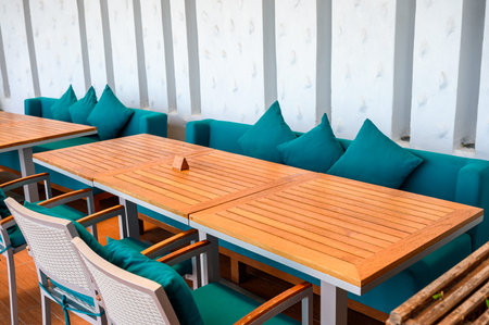 Wooden dining table with green pillows on sofa at restaurant