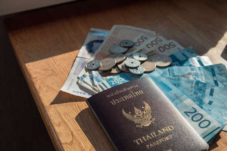 Currency Norway Kroner banknote with Coins and Thailand Passport on wooden tableの写真素材
