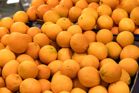 Fresh orange fruit pile on stall in supermarket