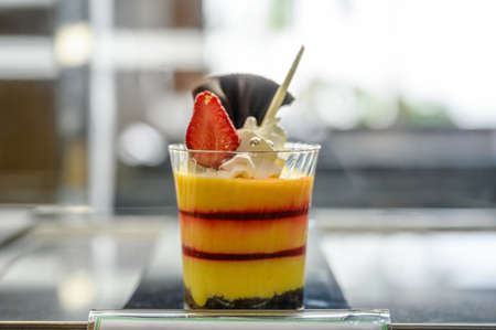 Cake smoothie mango with strawberry layers with chocolate cookies in glass cupの写真素材