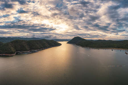 Scenery of tropical rainforest with blue sky in dam at evening. Aerial viewの写真素材
