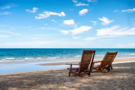 Empty two wooden chair on the beach in tropical sea on sunny. Summer and vacation conceptの写真素材
