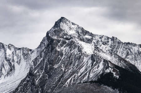 Big mountain peak with snow covered and overcast sky in Canadaの写真素材