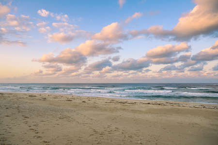 Colorful sky with clouds on the sea with beach in eveningの写真素材