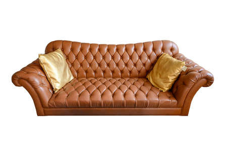 Orange vintage leather sofa buttoned with golden pillows. Isolated on white backgroundの写真素材