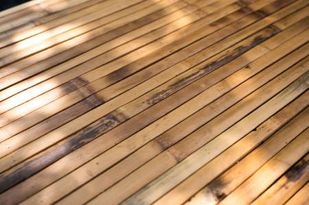Rustic brown wooden table top on blurred green plant in garden backyard on sunnyの写真素材
