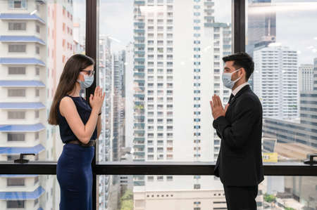 Attractive young caucasian business partner standing with crossed arms with smiling and looking at camera in modern office at business districtの写真素材