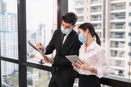 Attractive young caucasian business partner standing with crossed arms with smiling and looking at camera in modern office at business districtの写真素材