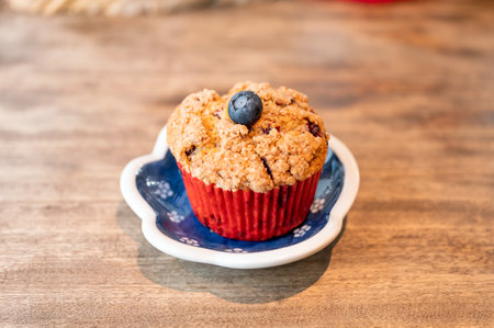 Homemade baked blueberry muffin on dish at wooden tableの写真素材