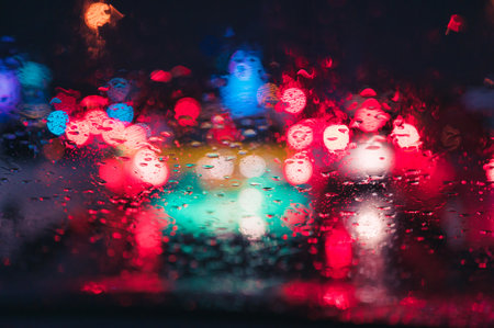 Abstract colorful bokeh raindrop on windshield in rainy day at night backgroundの写真素材