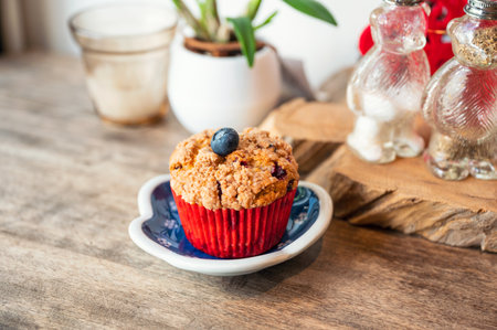 Homemade baked blueberry muffin on dish at wooden tableの写真素材