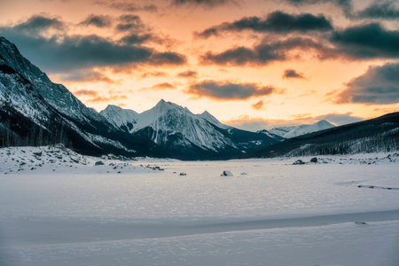 Beautiful scenery of sunrise over Medicine Lake with rocky mountains and frozen lake in Jasper national park, Alberta, Canadaの写真素材