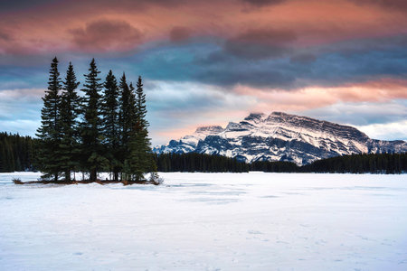 Beautiful view of Two Jack Lake with Mount Rundle and pine forest in winter on the evening at Banff national park, Alberta, Canadaの写真素材