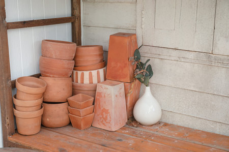 Group of stacked clay pot and flower vase in wooden shelf