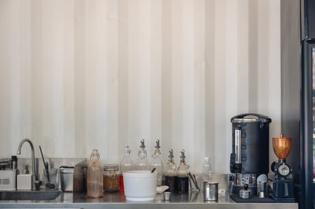 Equipment with coffee maker, bottles and raw materials for making coffee on counter bar in coffee shopの写真素材