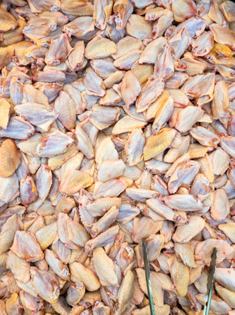 Raw chicken wings pile up on market stallの写真素材