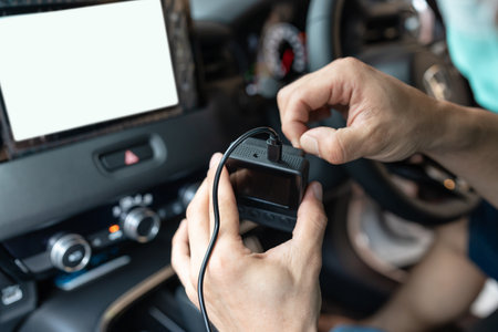 Hand of technician preparing and installing front camera car recorder inside carの写真素材