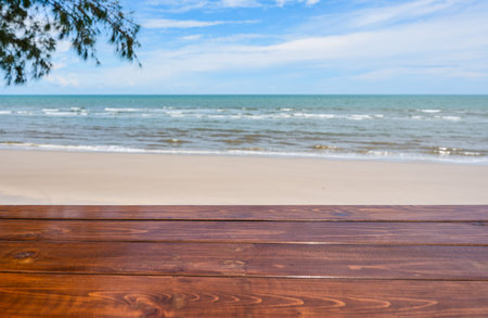 Wooden table top on blurred tropical sea beach on summertime background
