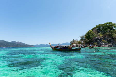 Traditional wooden boat in emerald sea on summer during sunny day at Lipe Island, Thailandの写真素材