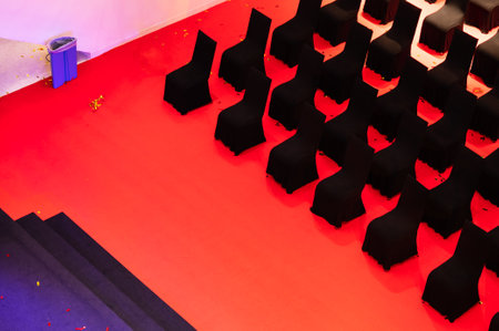 Row of empty black chairs on red floor in performance stage. Top viewの写真素材