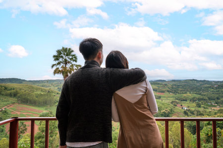 Sweet young asian couple embracing and admire on mountain hill in countryside during summer vacationの写真素材