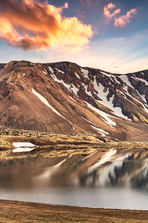 Majestic landscape of volcanic mountain range with snow covered and sunset sky in Icelandic highlands on Landmannalaugar at Icelandの写真素材