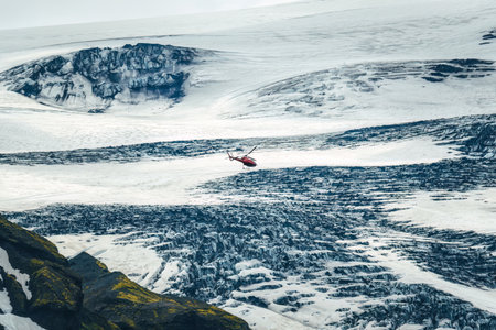 Sightseeing helicopter tour flying through glacier mountain with snow covered in Icelandic highlands at Icelandの写真素材