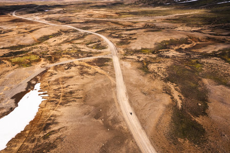 Aerial view of Cyclist riding on dirt road among the volcanic wilderness in Icelandic Highlands on summer at Icelandの写真素材