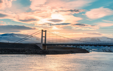 Beautiful sunset over suspension bridge on Jokulsarlon glacial river lagoon with iceberg floating in southern of Vatnajokull National Park at Icelandの写真素材