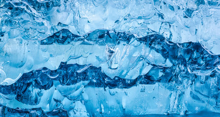 Close up abstract blue ice cracks from iceberg in glacier natural background