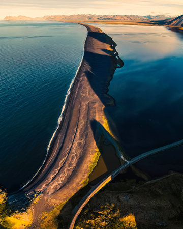 Aerial view of beautiful sunrise over volcanic mountain range in rural scene by the ocean of peninsula at summer in Icelandの写真素材