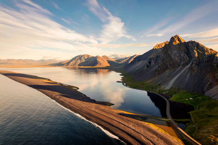 Aerial view of beautiful sunrise over volcanic mountain range in rural scene by the ocean of peninsula at summer in Icelandの写真素材