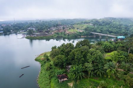 Aerial view of bridge over the river among tropical rainforest in the morning at countrysideの写真素材