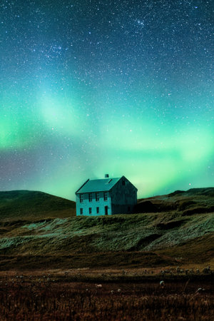 Fantastic scenic of Aurora borealis or northern lights glowing over abandoned scandinavian house on hill in remote location on the night at Icelandの写真素材