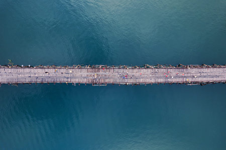 Above of ancient wooden Mon bridge with tourist walking over the dam in local Mon village at...