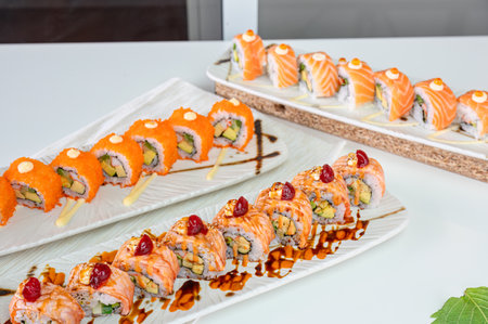 Ceramic tray with variety of salmon sushi roll with vegetables, appetizing meal in japanese restaurantの写真素材