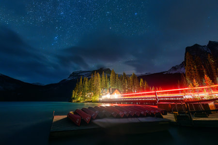 Night scene of Emerald Lake with wooden lodge, starry and canoe surrounding by rocky mountains in Yoho national park, British Columbia, Canadaの写真素材