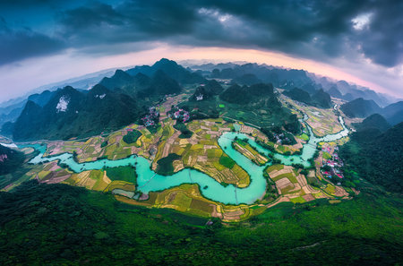 Panoramic aerial view of Phong Nam Valley with rice field and winding river through traditional village in countryside at Cao Bang, Vietnamの写真素材