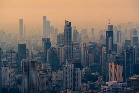 Cityscape of crowded financial skyscraper in dust and smog during the morning at Bangkok city,...