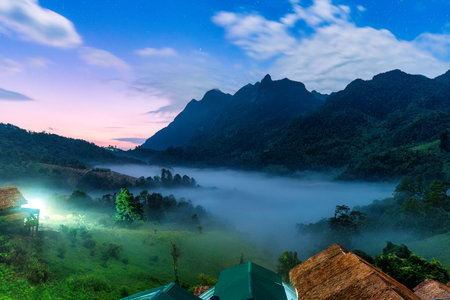 Scenic landscape of Doi Luang Chiang Dao limestone mountain with foggy and local tribe village in the dawn at Ban Na Lao Mai, Chiang Dao, Chiang Mai, Thailandの写真素材