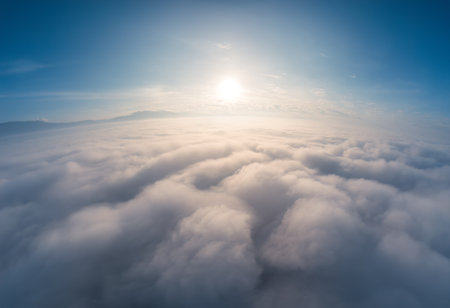 Panoramic view of sunrise shining over fluffy cloudy with foggy and blue sky creates serene and tranquil atmosphereの写真素材