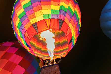 Colorful hot air balloon with flame burning in the night at festivalの写真素材