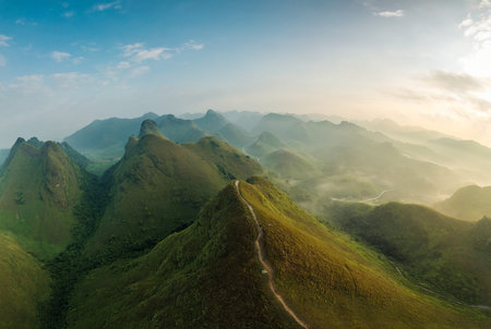 Aerial view of Beautiful Ba Guang grass hill, Mountain range with fog and villager bringing horse to...